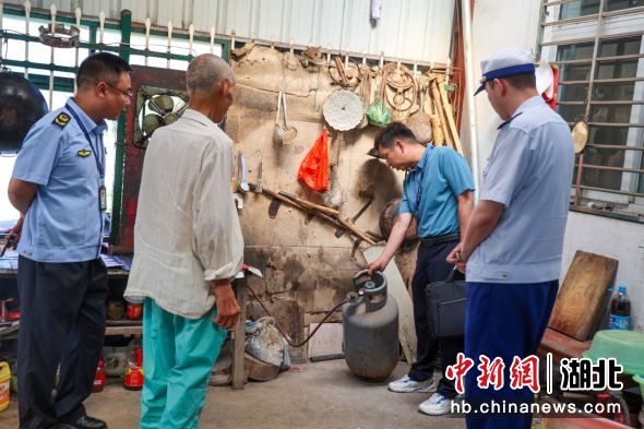 联合检查组对乡镇液化气经营点钢瓶进行检查。魏欢欢 摄