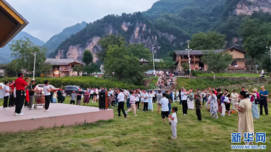 迴龙坪组织当地特色文化表演，吸引众多游客观看。新华网发 柯祎 摄