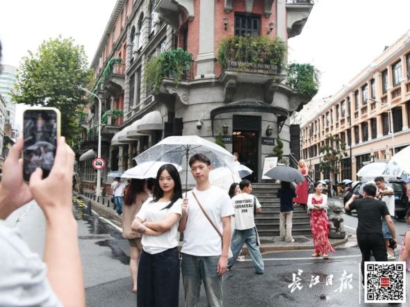 游客冒雨打卡巴公房子。记者詹松 摄